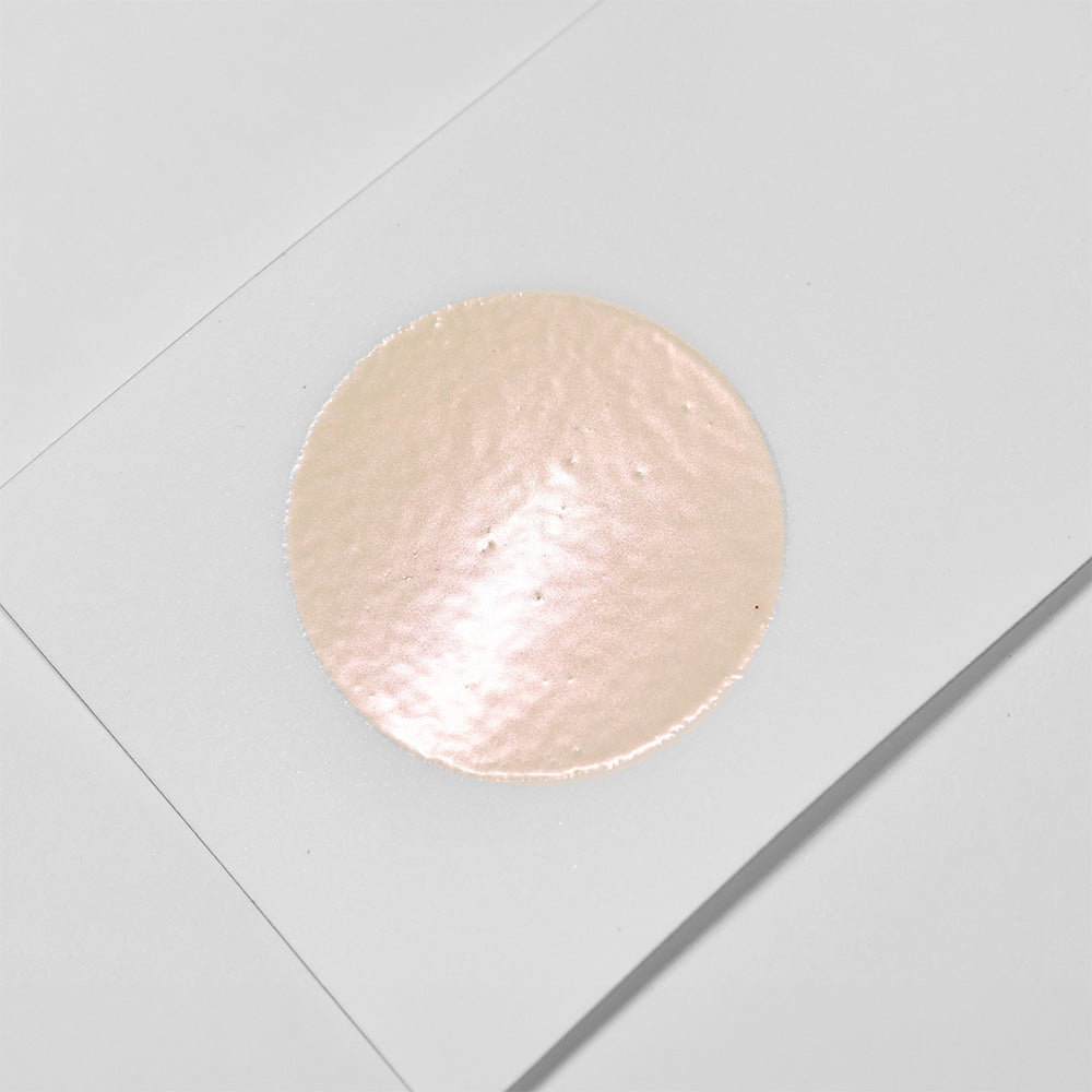 Ein glänzender, kreisförmiger, hellbeiger Aufkleber aus WOW Embossing Powder befindet sich mittig auf einem weißen, rechteckigen Blatt - perfekt für Bastelprojekte.