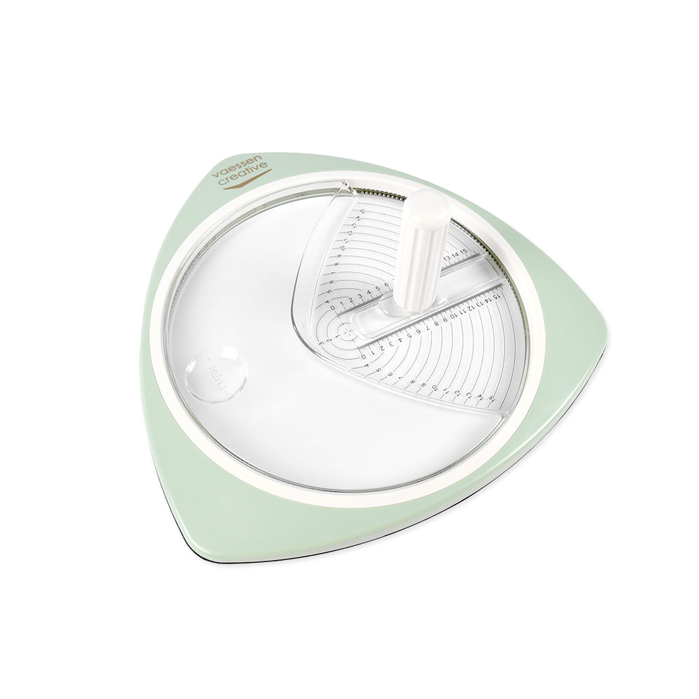 Ein grün-weißes, rundes Vaessen-Küchenwerkzeug mit Griff und Messmarkierungen auf weißem Hintergrund - ideal für präzise Schnitte in der Küche oder bei Bastelprojekten.