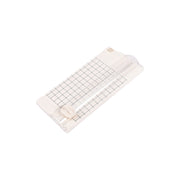 Eine beigefarbene Vaessen Papierschneidemaschine mit gerasterter Schneidefläche und Schiebeblatt - ideal für präzise Papierprojekte - auf weißem Hintergrund.