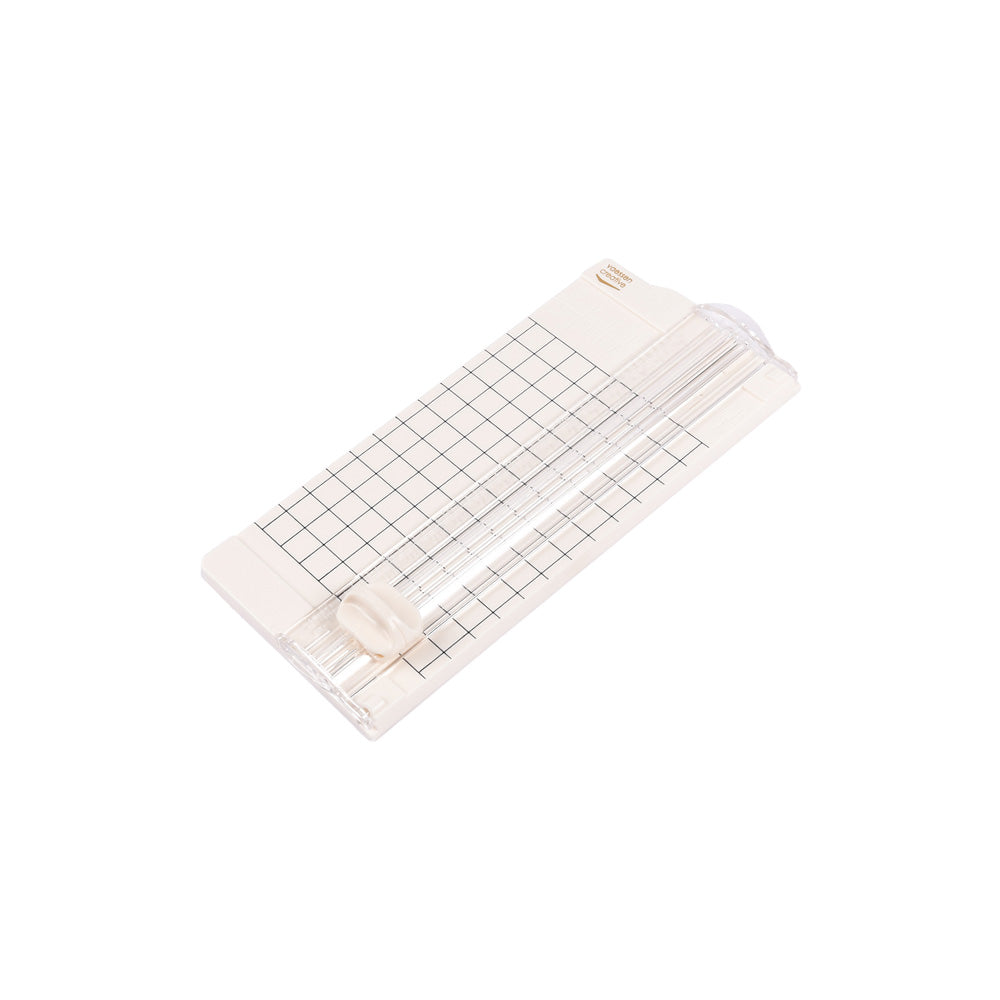 Eine beigefarbene Vaessen Papierschneidemaschine mit gerasterter Schneidefläche und Schiebeblatt - ideal für präzise Papierprojekte - auf weißem Hintergrund.