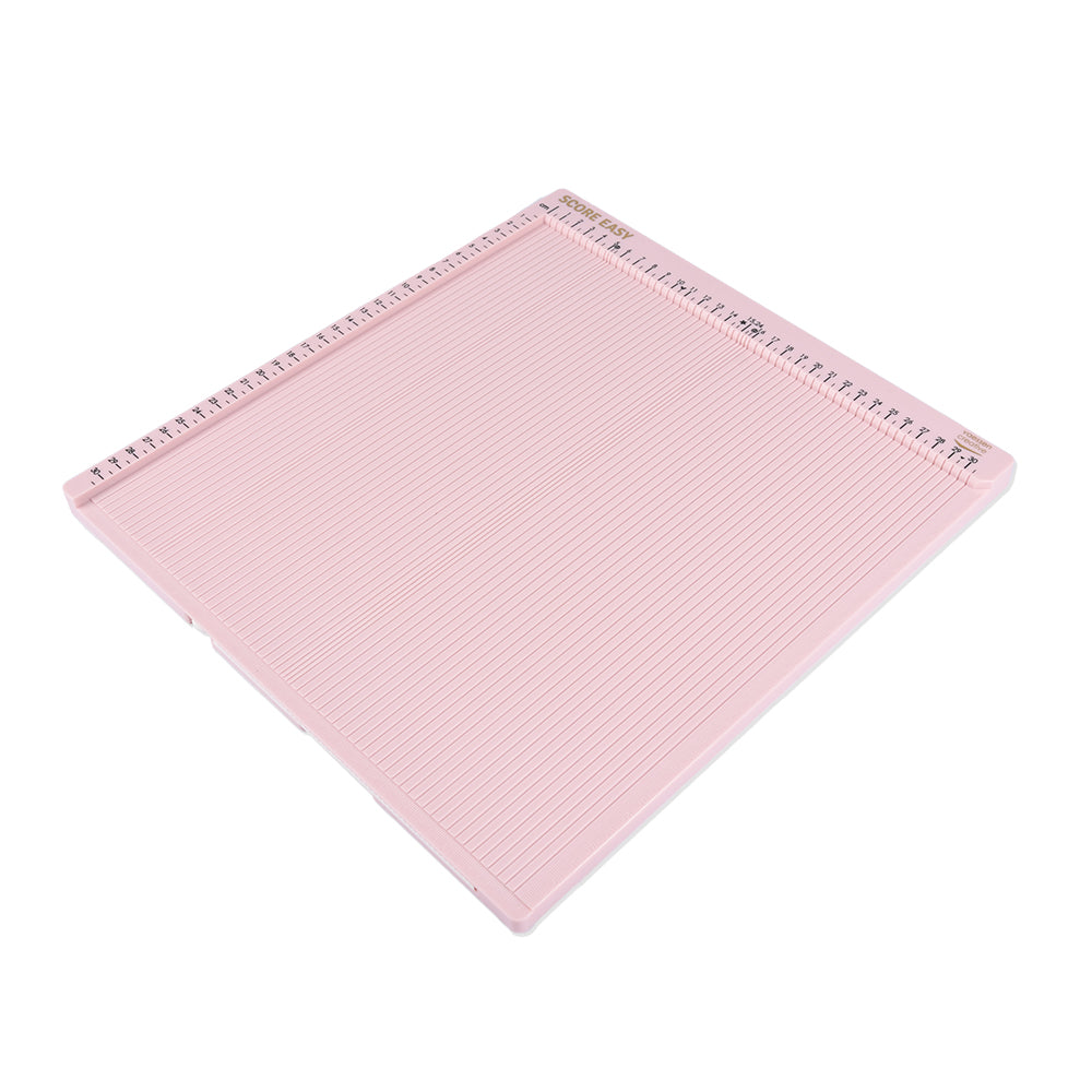 Ein rosafarbenes Vaessen Falzbrett mit Messmarkierungen am oberen und linken Rand, ideal für präzise Scrapbook- oder Bastelpapier-Bastelprojekte.