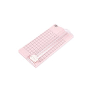 Ein rosafarbener Vaessen Mini Papierschneider mit Gittermuster und Schiebeklinge, ideal zum Schneiden von Bastelpapier, wird auf weißem Hintergrund gezeigt.