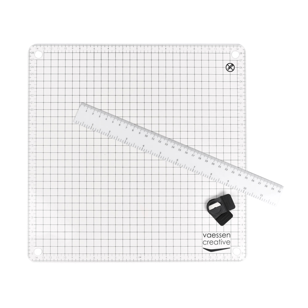 Eine selbstheilende Vaessen Schneidematte mit Quadratgitter, auf der ein Lineal und ein schwarzes Bastel-Universalmesser liegen.