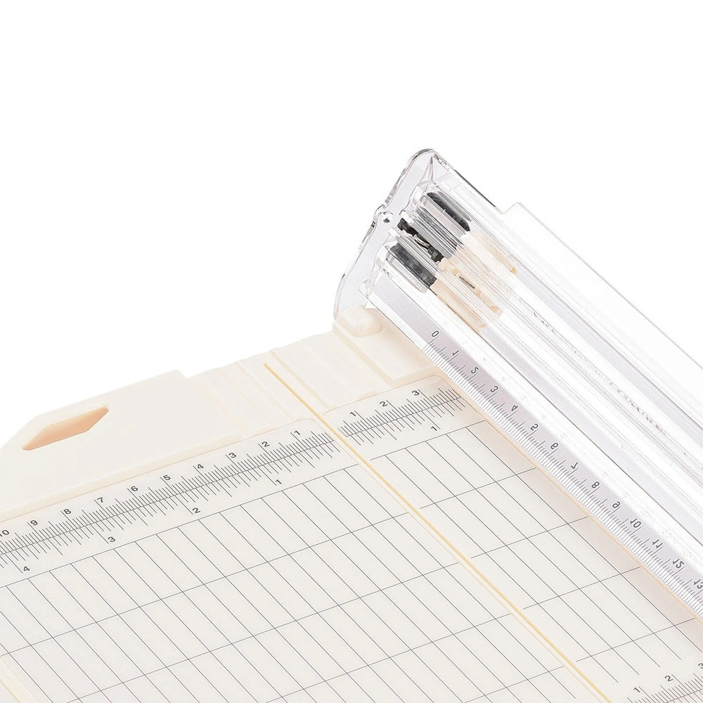 Eine Nahaufnahme eines Vaessen Papierschneiders mit Lineal und Schneidemesser auf einer gerasterten Fläche, mit präziser Rillfunktion für perfekte Faltungen.